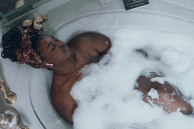 Women having a bubble bath looking relaxed - Self-care is important but be aware