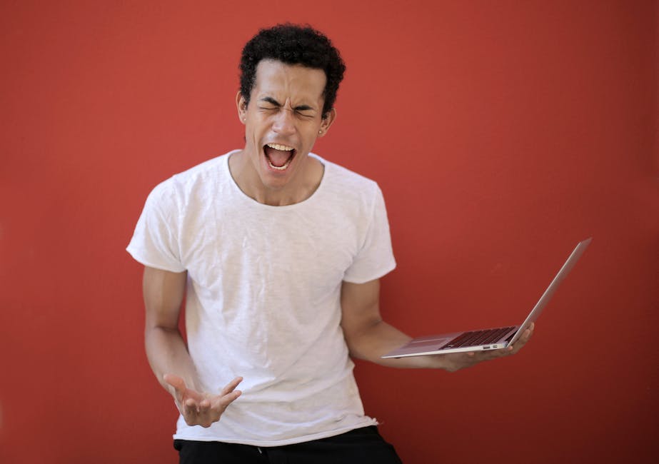 Break Free from the Yeah Buts. - a man with short black hair screaming while holding a laptop